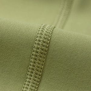 Close-up of green fabric with a stitched seam running diagonally across the image.