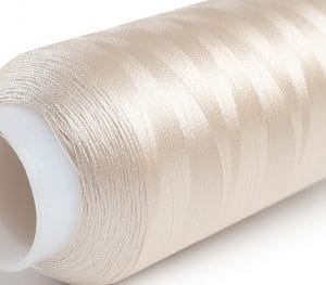 Roll of metallic beige sewing thread on a white spool