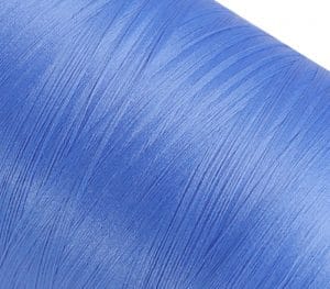 Close-up of blue fabric with fine diagonal fibers and subtle sheen.