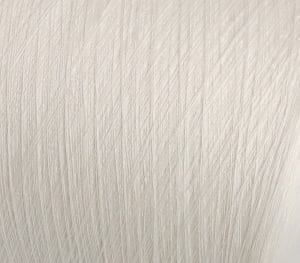 Close-up of a pale textured surface with numerous diagonal scratches or grooves throughout.