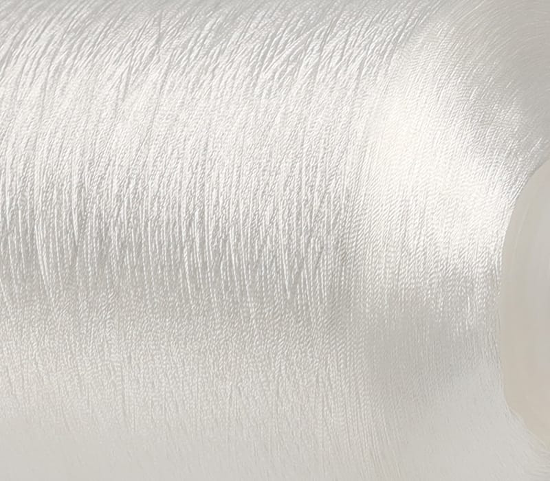 Close-up of a brushed silver metal surface with a partial beige circular object on the right.
