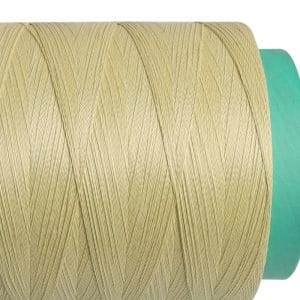 Close-up of a pale yellow thread spool wrapped around a green core, with multiple plies visible.