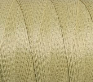 Close-up of pale yellow sewing thread twisted into neat strands on a spool.