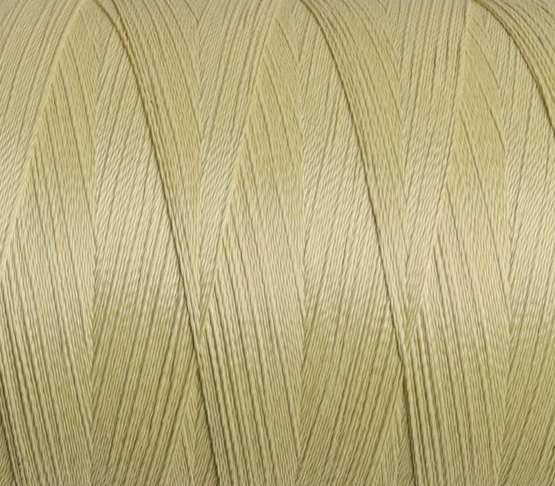 Close-up of pale yellow sewing thread twisted into neat strands on a spool.
