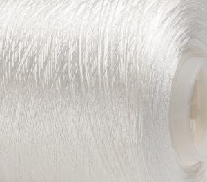 Close-up of white thread tightly wound around a plastic spool.