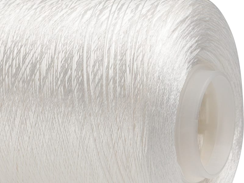 Close-up of white sewing thread wound around a plastic spool core.
