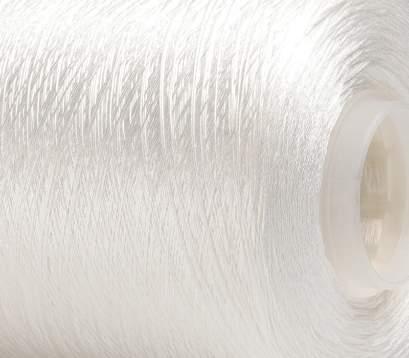 Close-up of white thread wound around a plastic spool, viewed from the side.