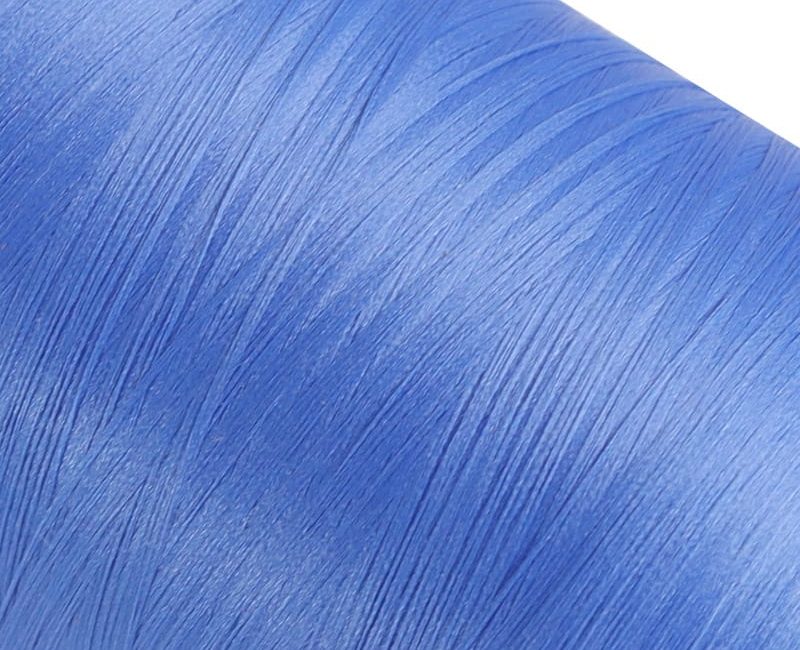 Close-up of blue fabric with fine diagonal fibers and subtle sheen.